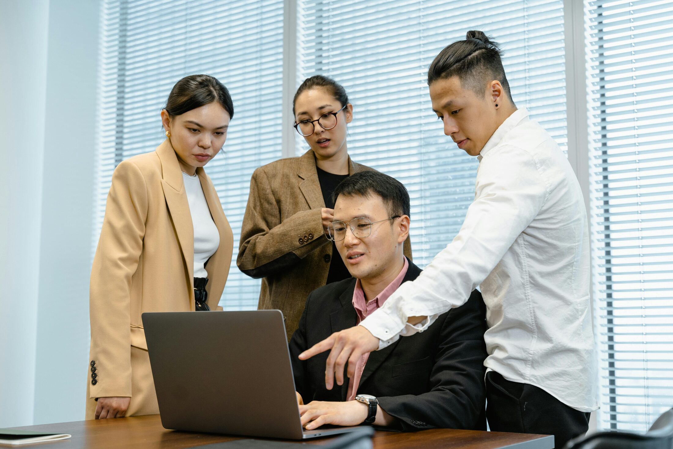 Team members reviewing information on a laptop in an office